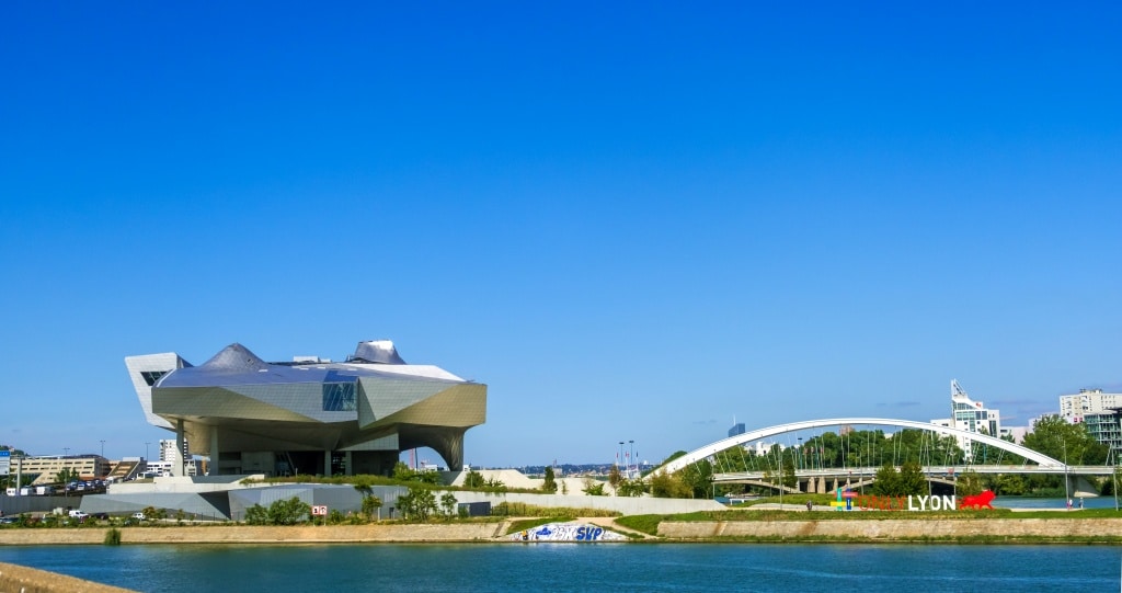 Lyon, France Musee des Confluences museum. The Pont Raymond Barre bridge over the Rhone river and a Only Lyon slogan of Lyon city